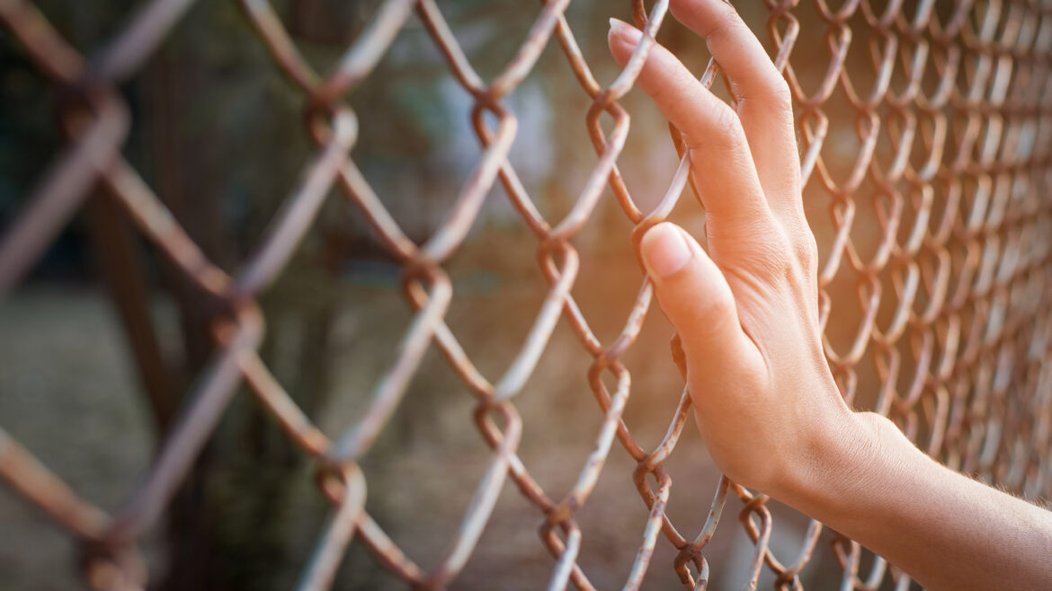 Photo of a hand holding a fence