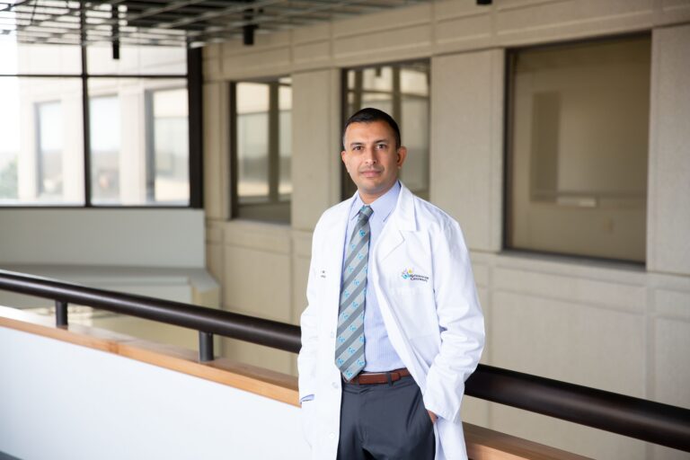 Dr. Anup D. Patel, MD standing in a hallway wearing a white lab coat