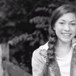 Black and white image of teen girl posing outside