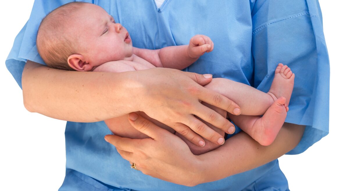 Nurse with scrubs holding an infant