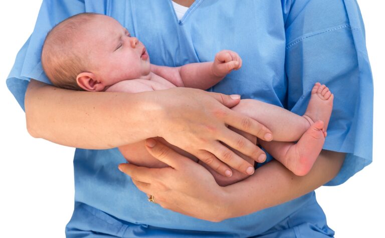 Nurse with scrubs holding an infant