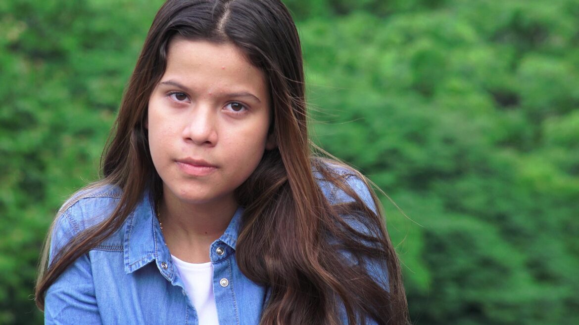 A girl looking serious at the camera outside