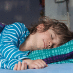 Color image of young boy asleep in bed