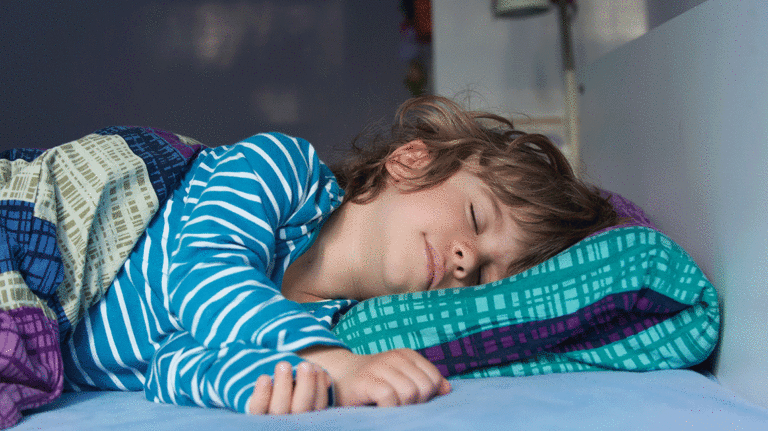 Color image of young boy asleep in bed