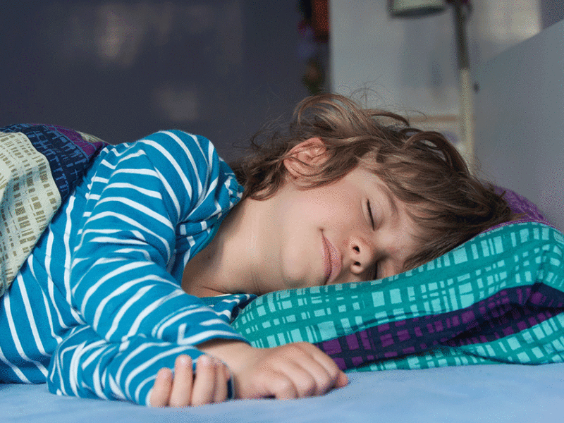 Color image of young boy asleep in bed