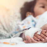 Mother hand holding child hand who have IV solution in the hospital