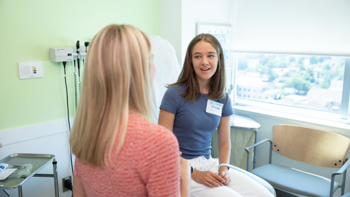teenage patient and doctor talking in an exam room